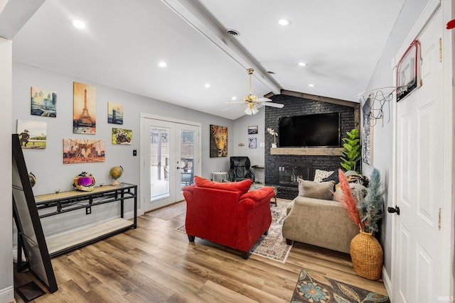 living room with french doors, recessed lighting, lofted ceiling with beams, a brick fireplace, and wood finished floors