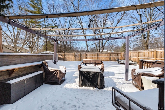 yard layered in snow featuring a fenced backyard and a pergola