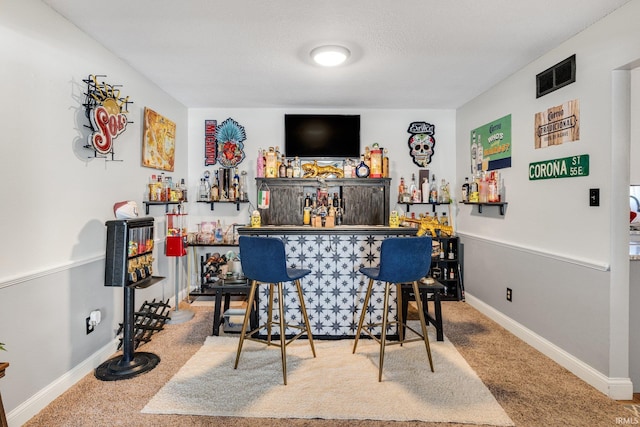 bar with carpet floors, baseboards, visible vents, and a dry bar