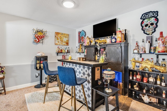 bar with a textured ceiling, a dry bar, and baseboards