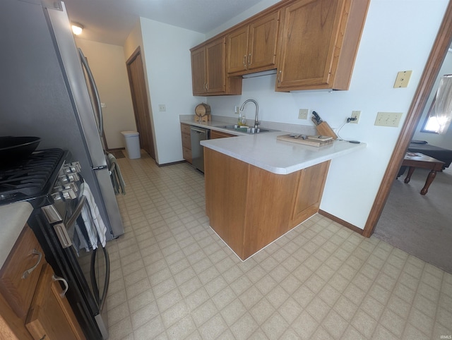 kitchen featuring range with gas stovetop, light floors, light countertops, a sink, and dishwasher