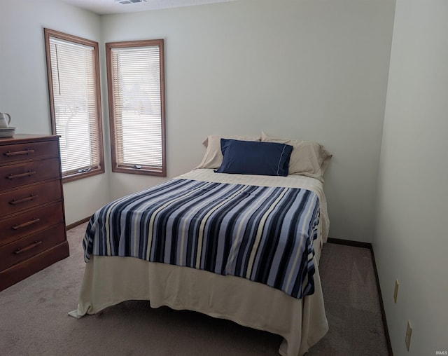 bedroom with baseboards and light colored carpet