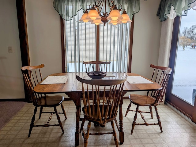 dining room with light floors and an inviting chandelier