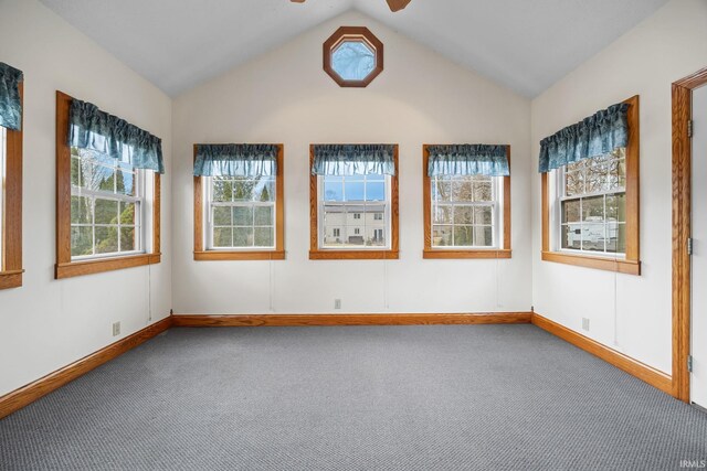 unfurnished room featuring lofted ceiling, baseboards, a ceiling fan, and carpet flooring