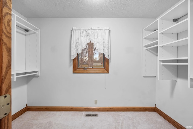 walk in closet with light carpet and visible vents