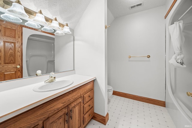 bathroom featuring visible vents, toilet, vanity, a textured ceiling, and tile patterned floors