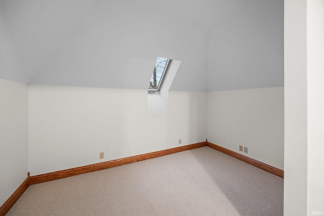 bonus room with vaulted ceiling with skylight, carpet flooring, visible vents, and baseboards