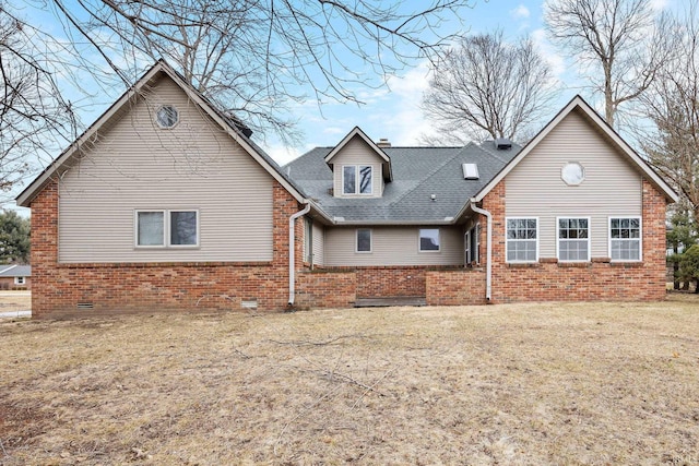 back of property featuring crawl space, brick siding, a lawn, and roof with shingles