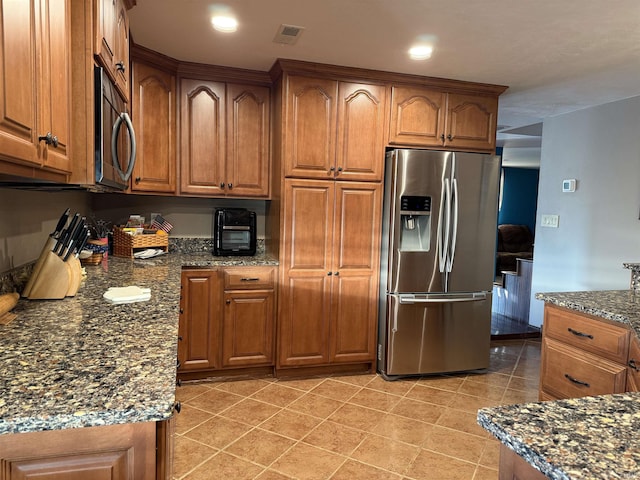 kitchen featuring brown cabinetry, visible vents, and stainless steel appliances