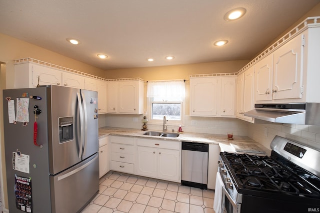 kitchen with appliances with stainless steel finishes, light countertops, a sink, and white cabinetry