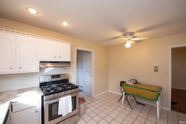 kitchen featuring under cabinet range hood, stainless steel appliances, white cabinetry, light countertops, and decorative backsplash