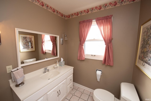 bathroom featuring toilet, baseboards, and vanity