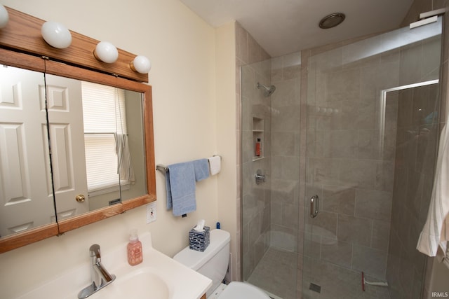 bathroom featuring toilet, a stall shower, and vanity