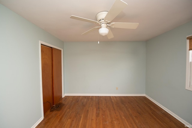 spare room featuring ceiling fan, wood finished floors, and baseboards