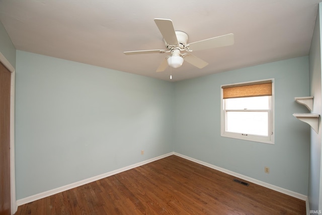 unfurnished room with a ceiling fan, visible vents, baseboards, and wood finished floors