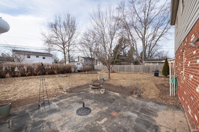 view of yard with a patio area, a fenced backyard, and a fire pit