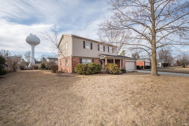 view of front of property featuring a front lawn, concrete driveway, brick siding, and an attached garage