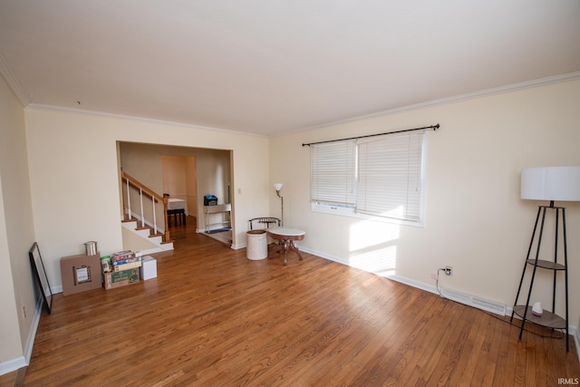 empty room with wood finished floors, visible vents, baseboards, ornamental molding, and stairway