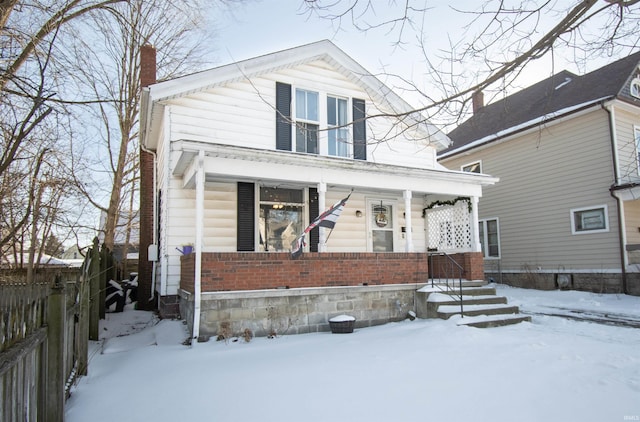 view of front of property featuring brick siding, fence, and a chimney