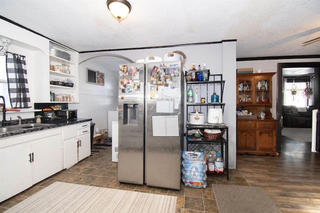 kitchen featuring a sink, white cabinets, open shelves, dark countertops, and stainless steel fridge