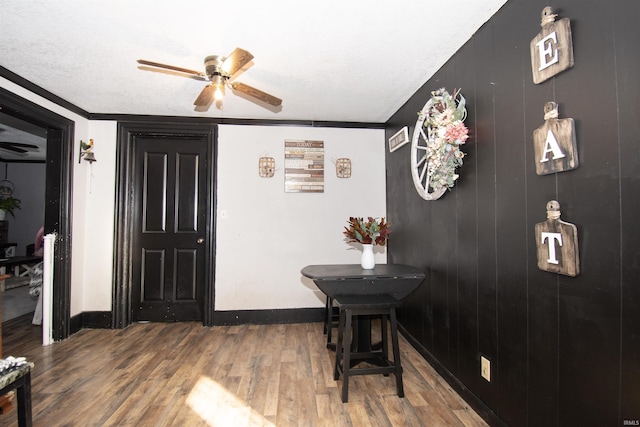 foyer with a ceiling fan, crown molding, baseboards, and wood finished floors