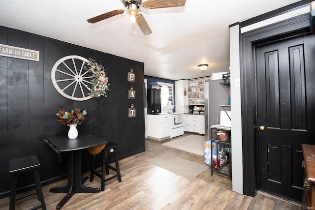 dining space featuring light wood-type flooring and ceiling fan