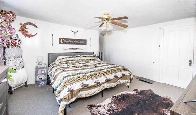 carpeted bedroom featuring a textured ceiling and ceiling fan