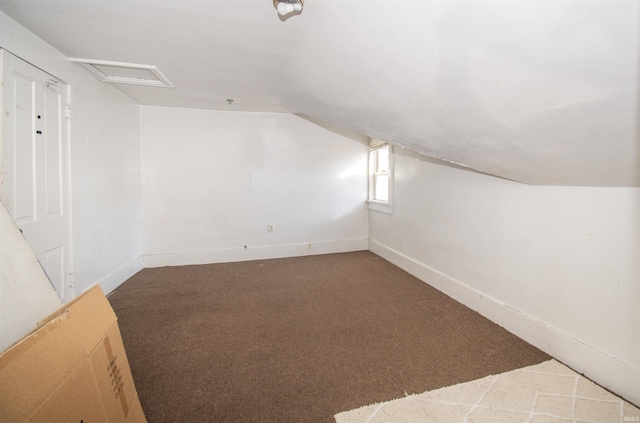 bonus room with attic access, lofted ceiling, carpet floors, and baseboards