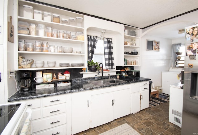 kitchen featuring stove, a sink, white cabinetry, open shelves, and washer / clothes dryer