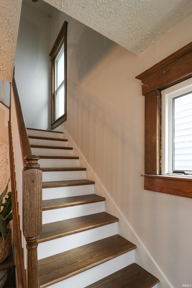 stairs featuring a textured ceiling