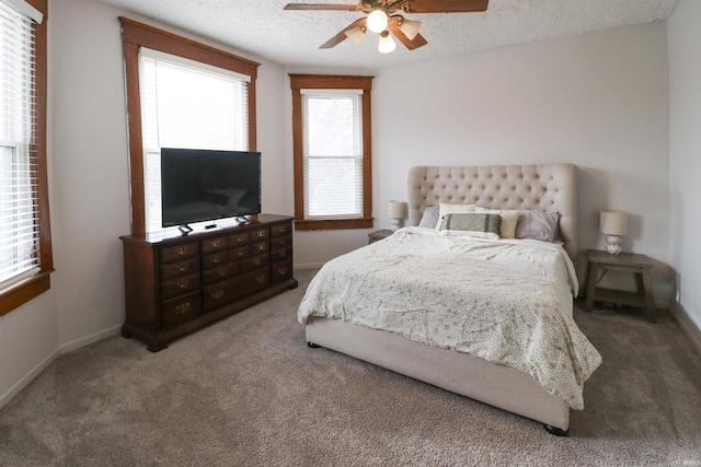 carpeted bedroom featuring a ceiling fan, a textured ceiling, and baseboards