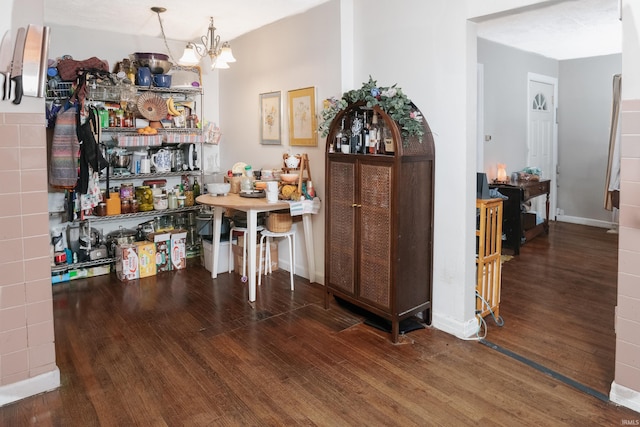 dining space with a chandelier, wood finished floors, and baseboards