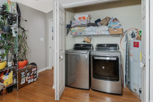 laundry room with laundry area, water heater, light wood-style floors, and washer and dryer