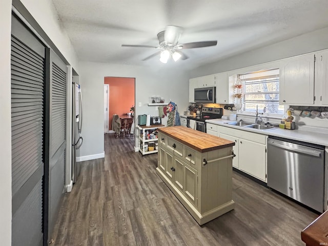 kitchen featuring a sink, stainless steel appliances, wooden counters, and dark wood-style flooring