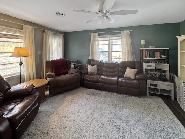 living area featuring a ceiling fan and visible vents