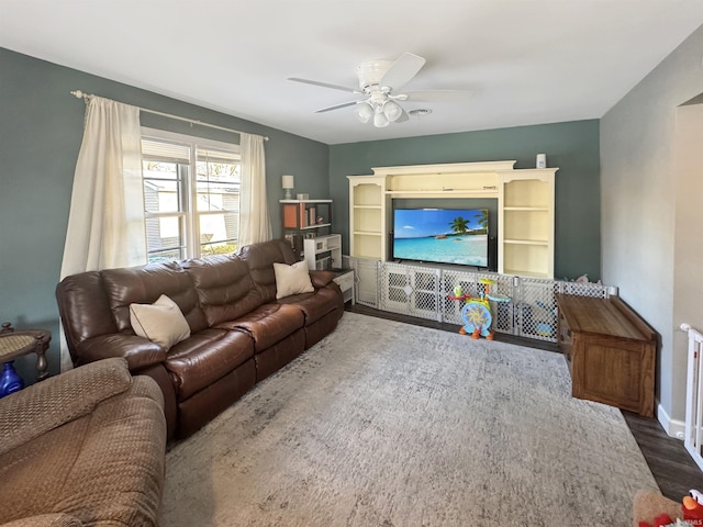 living room featuring a ceiling fan, wood finished floors, and baseboards