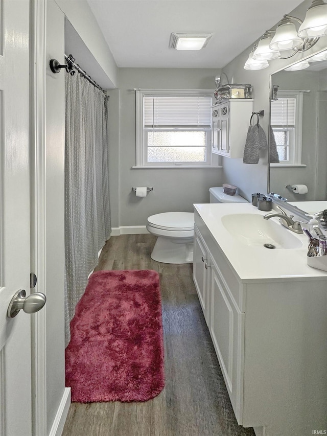 full bath with vanity, wood finished floors, baseboards, curtained shower, and toilet