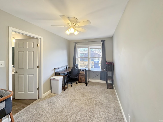 office space featuring carpet flooring, a ceiling fan, and baseboards