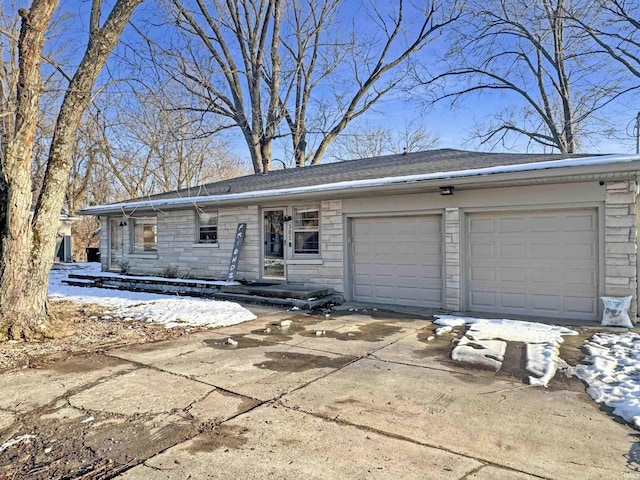 view of front of house featuring stone siding, driveway, and an attached garage