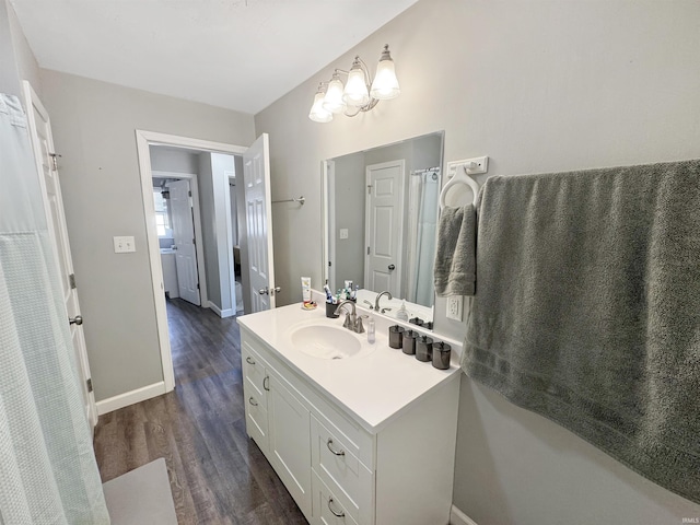 bathroom with vanity, baseboards, and wood finished floors