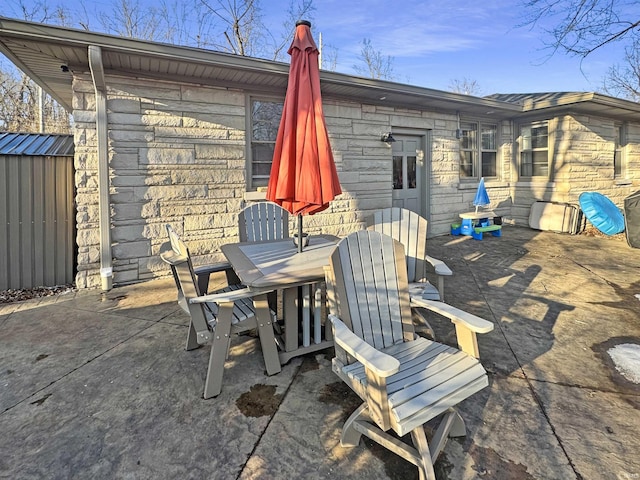 view of patio featuring an outbuilding, outdoor dining space, and a shed