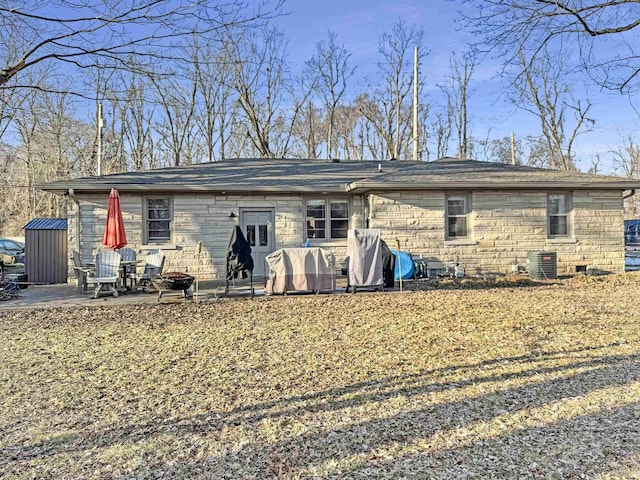 back of house featuring stone siding, central AC, and a patio area