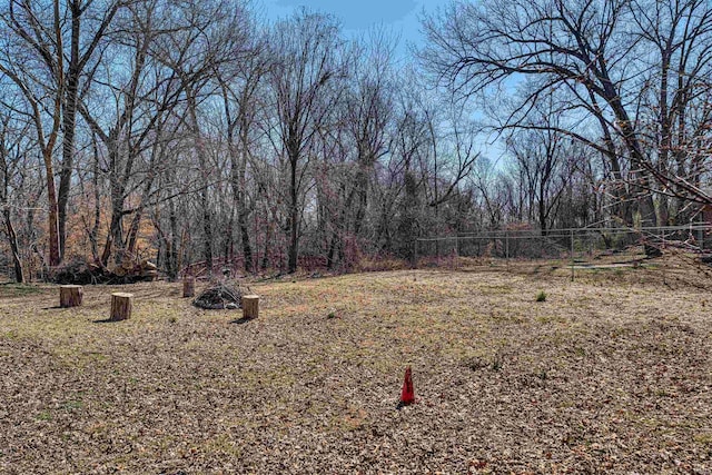 view of yard featuring a view of trees and fence