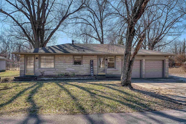 ranch-style home featuring stone siding, driveway, an attached garage, and a front lawn