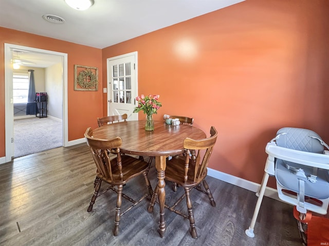 dining space with visible vents, baseboards, and wood finished floors