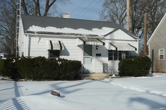 view of front of home featuring metal roof and a chimney