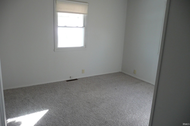 unfurnished room featuring carpet and visible vents