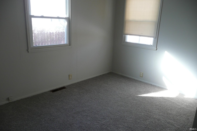 carpeted spare room featuring visible vents