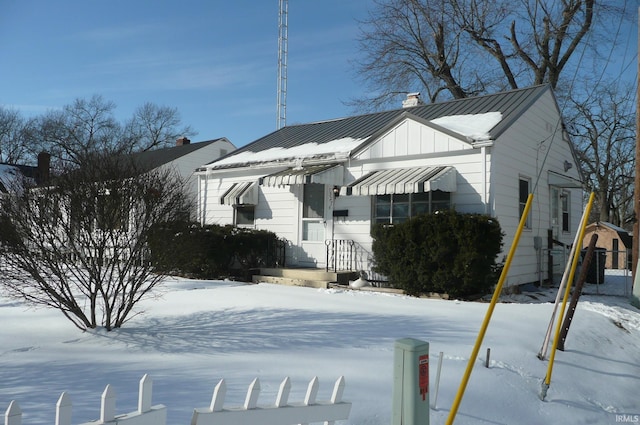 view of front facade featuring board and batten siding, a standing seam roof, and metal roof