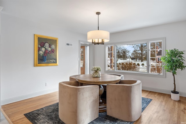 dining area featuring wood finished floors, visible vents, and baseboards